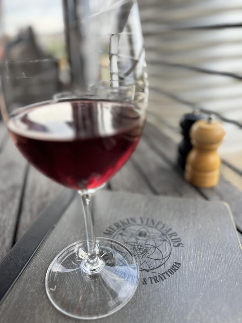 A glass of red wine on a vineyard trattoria menu in Cottonwood