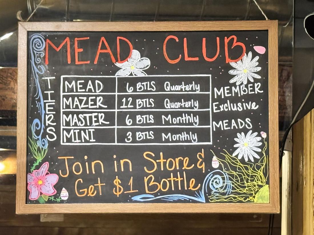 A chalkboard in a Prescott meadery listing four club tiers, monthly and quarterly