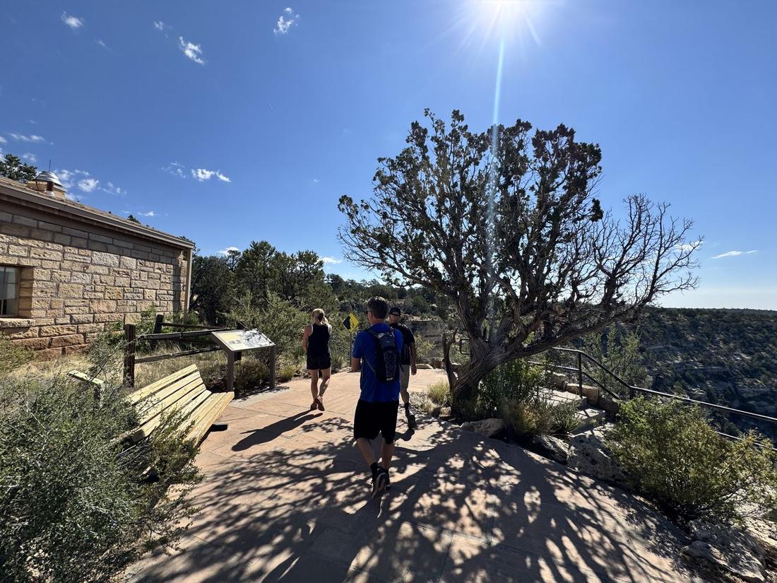 Hikers on a sunny trail along the rim at Walnut Canyon near Flagstaff
